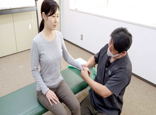 手の施術を受ける女性