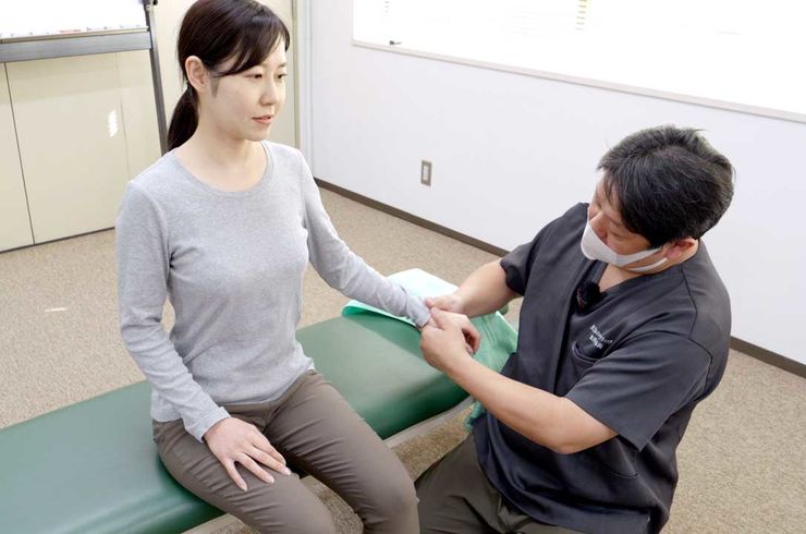 手の施術を受ける女性