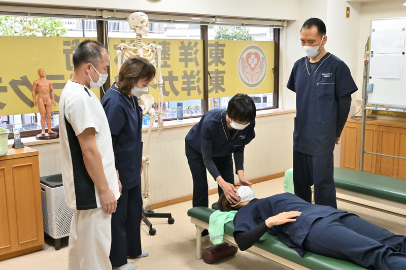 生徒が別の生徒の顎関節を触っている